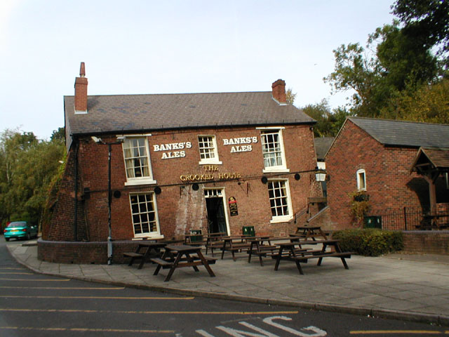 a brick building with tables outside in front
