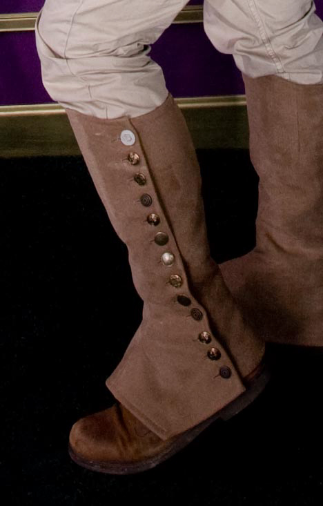 a person's legs and boots in white pants