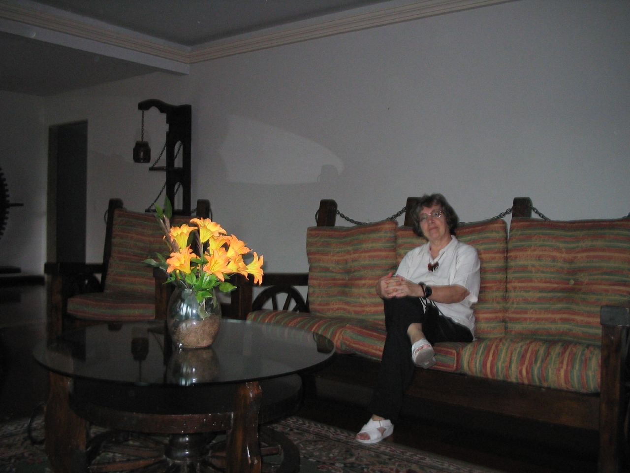 a woman sitting on top of a couch next to a table