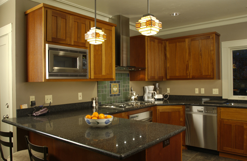 the kitchen has a granite counter top and wooden cabinets