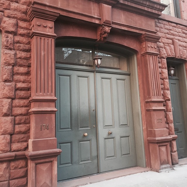 a large brown building with a tall wooden door