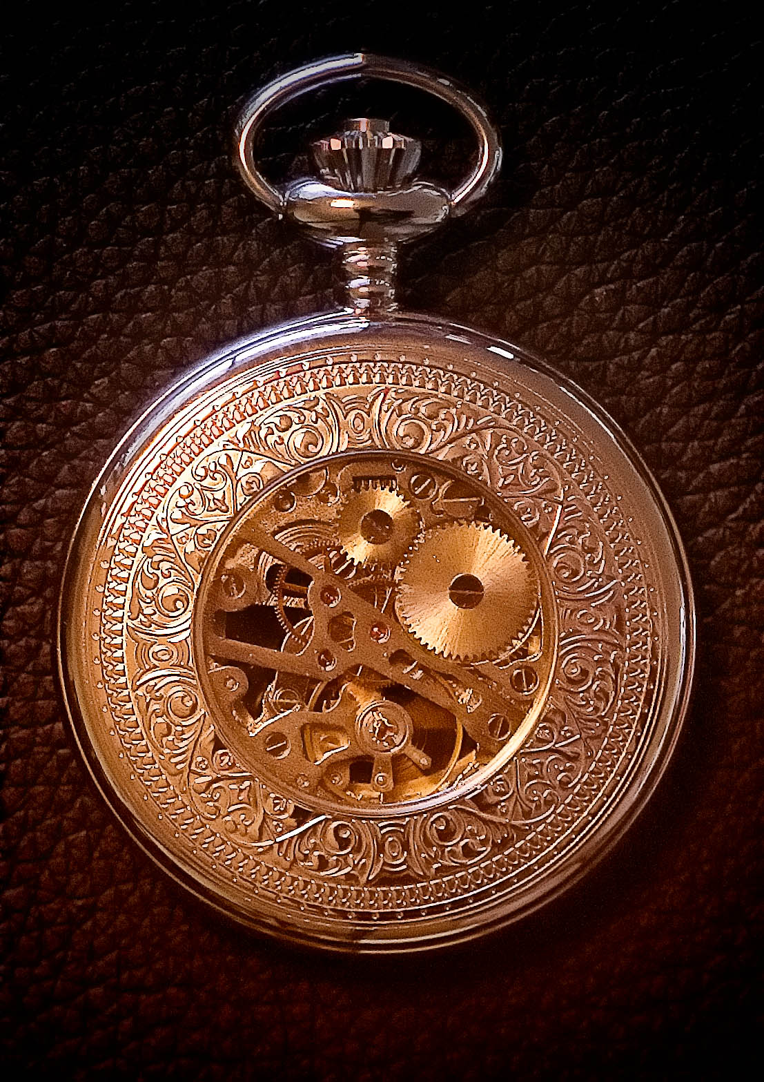 an old pocket watch is engraved on leather