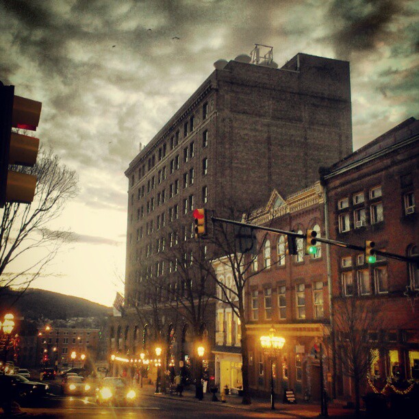 street lights in the city at dusk with cars moving down the road