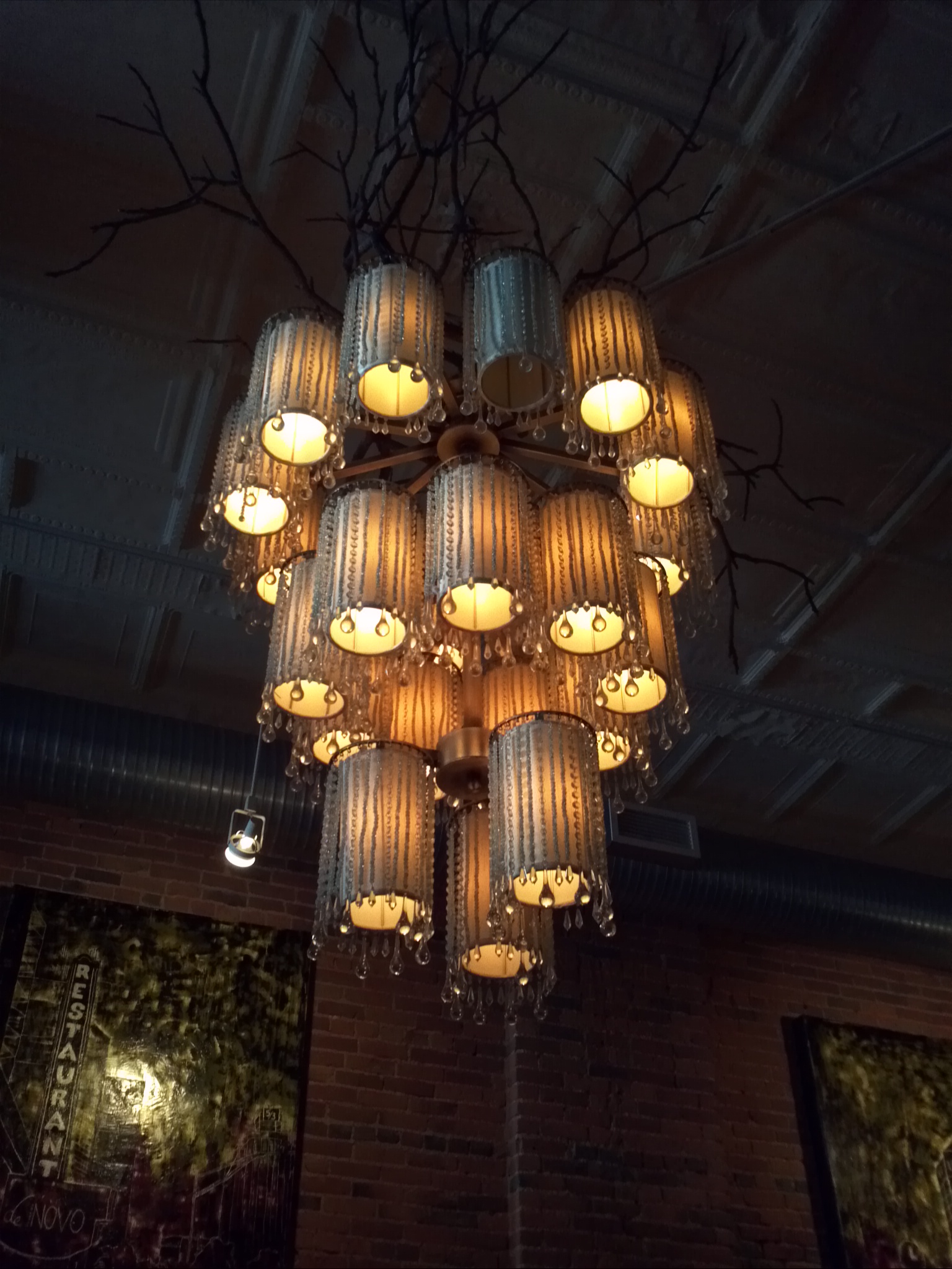 an artistic and unique light fixture hangs in a dining room