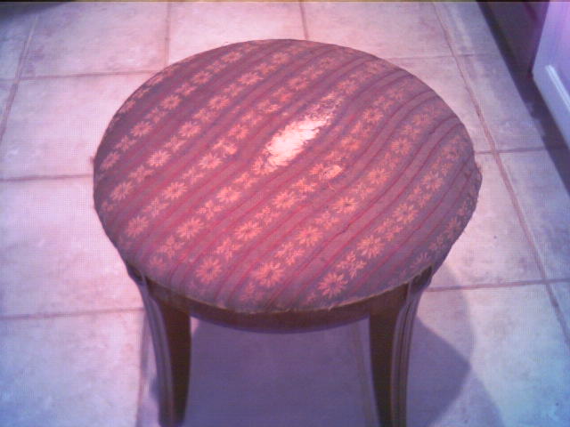 a little stool sitting on a tile floor next to a door