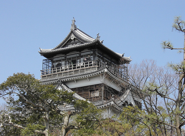 an asian style structure with a bird perched on top of it