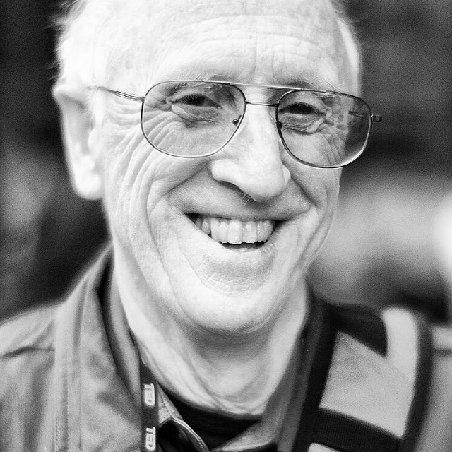 a older man wearing glasses looking to the right