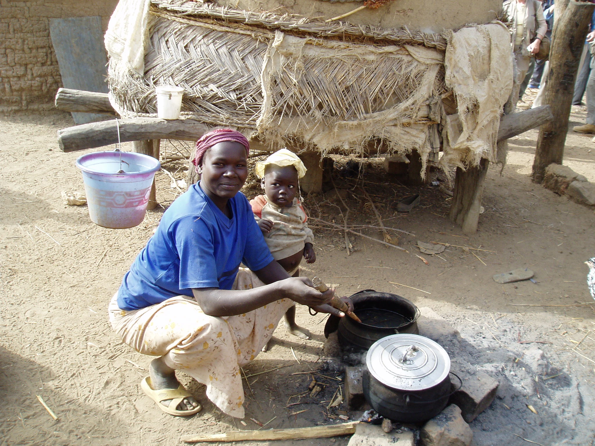 two women sit next to a small kitchen and cook