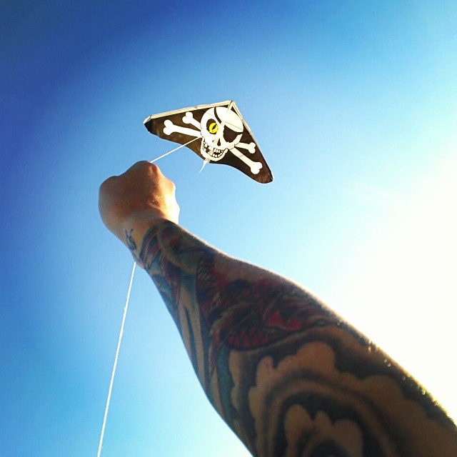 a close up of a person holding a kite with skull decorations