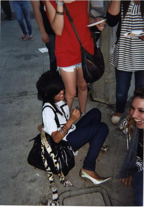 a young child sitting on the ground with a woman looking at it