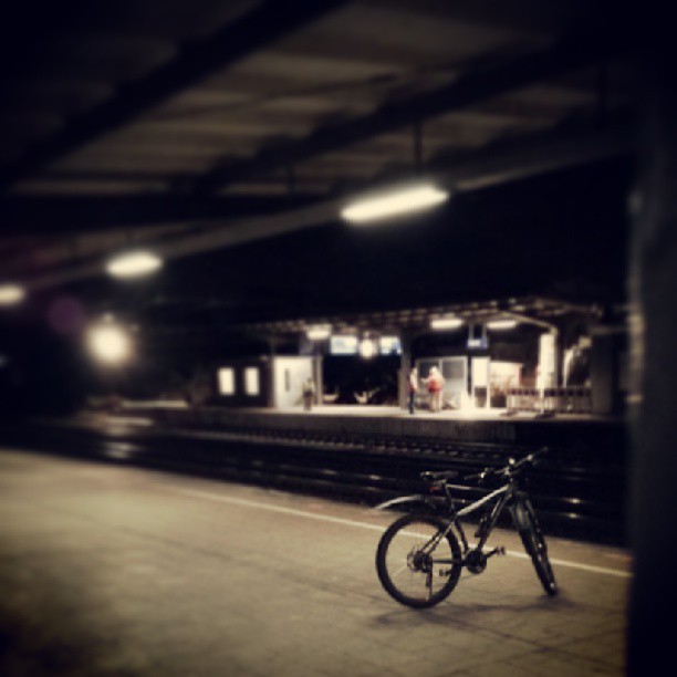 a bike parked at a train station at night