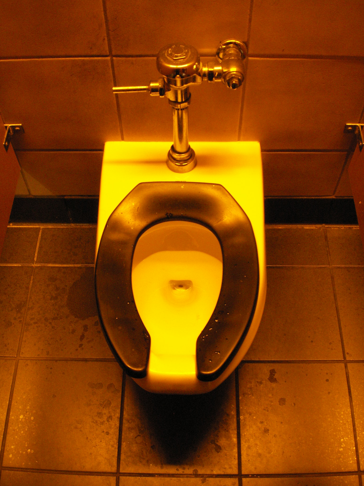 a yellow toilet is glowing with yellow light