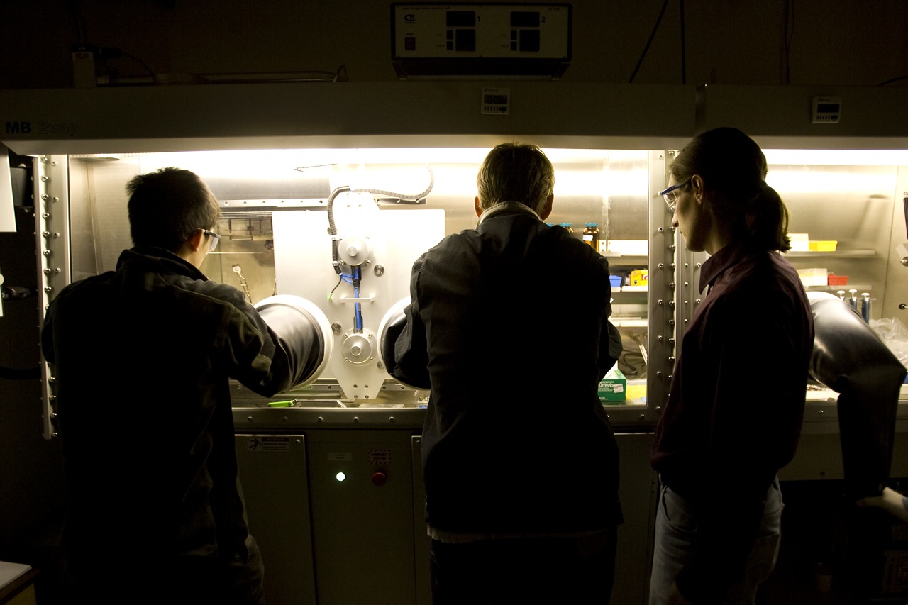 people looking at a refrigerator with a number of food items in it