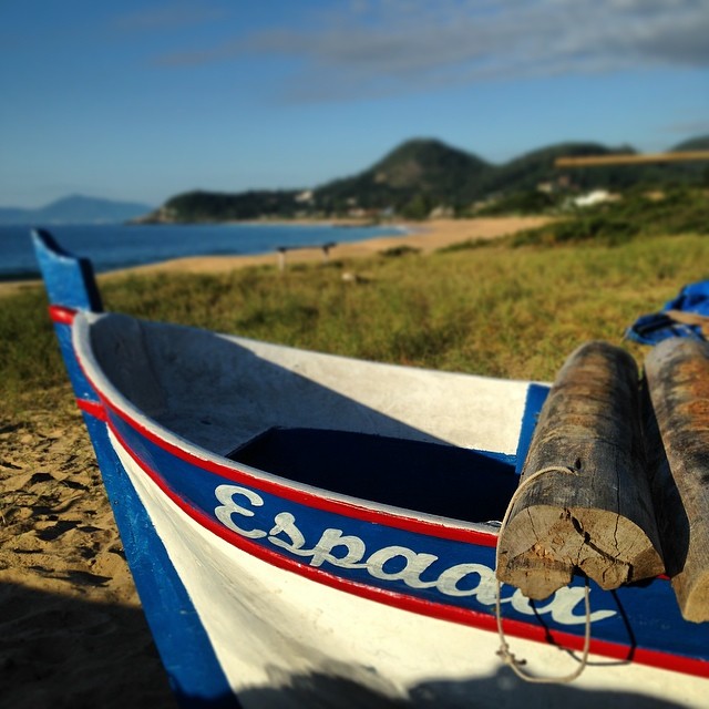 an old wooden boat is sitting on the sand