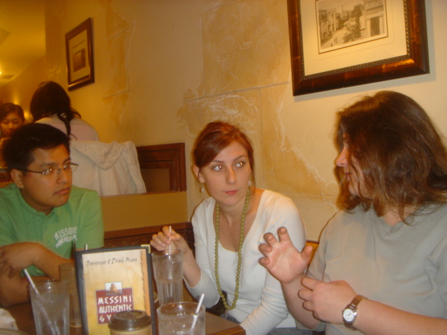 three people are sitting at a table with drinks
