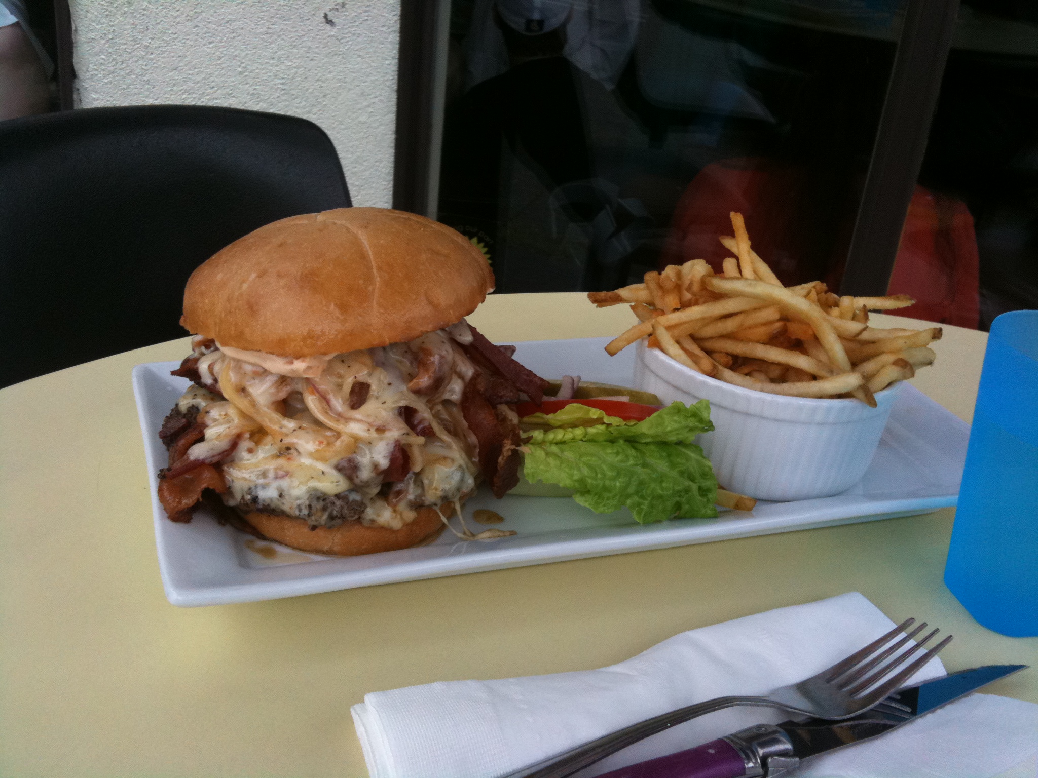 the plate is holding a large sandwich and fries