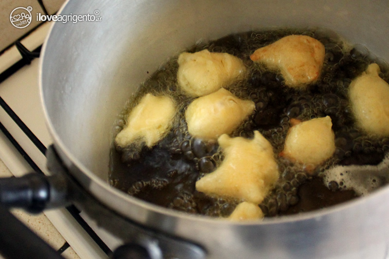 some fried food is being cooking in a silver pot
