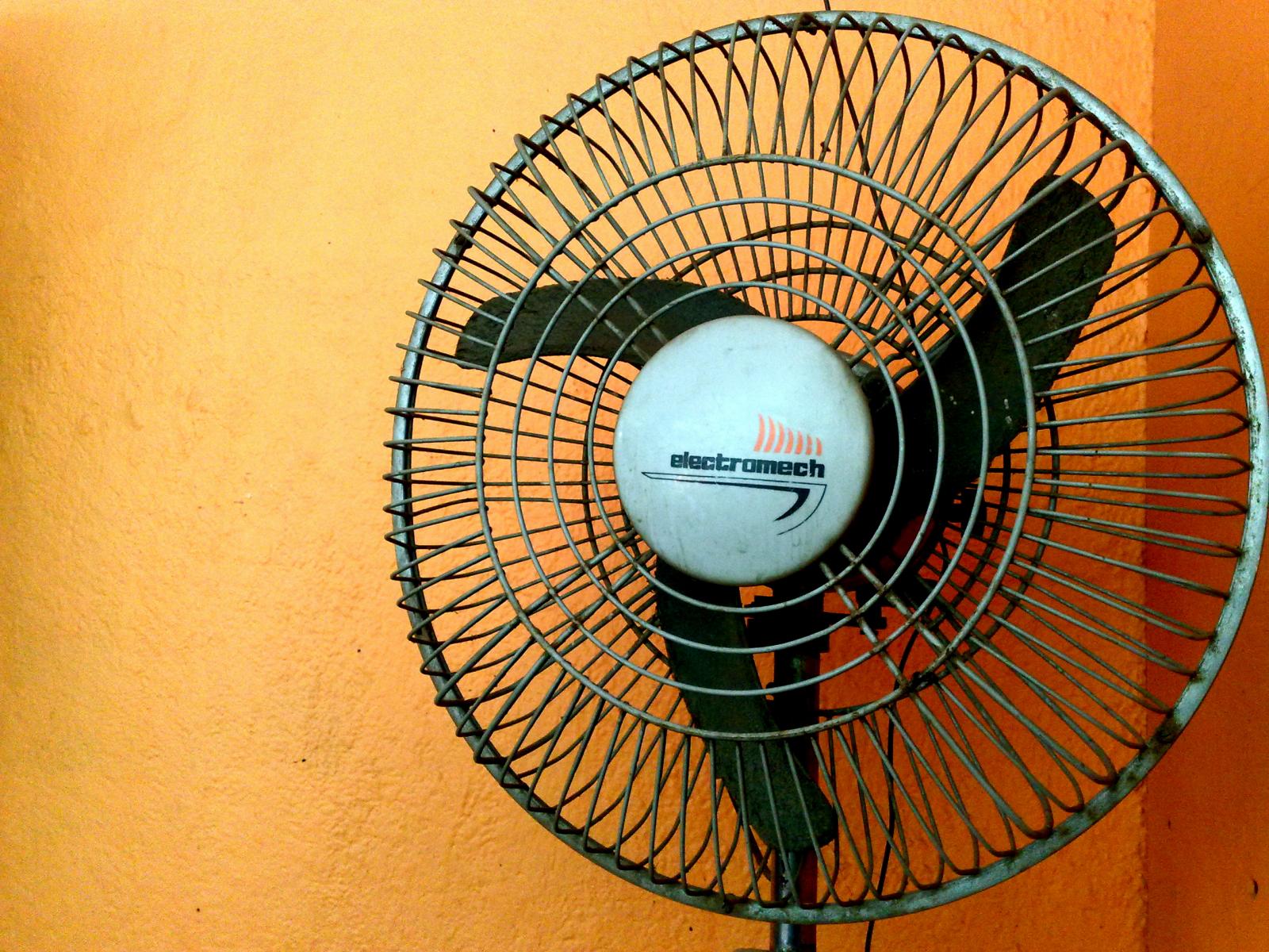 an old style metal cooling fan on a wall