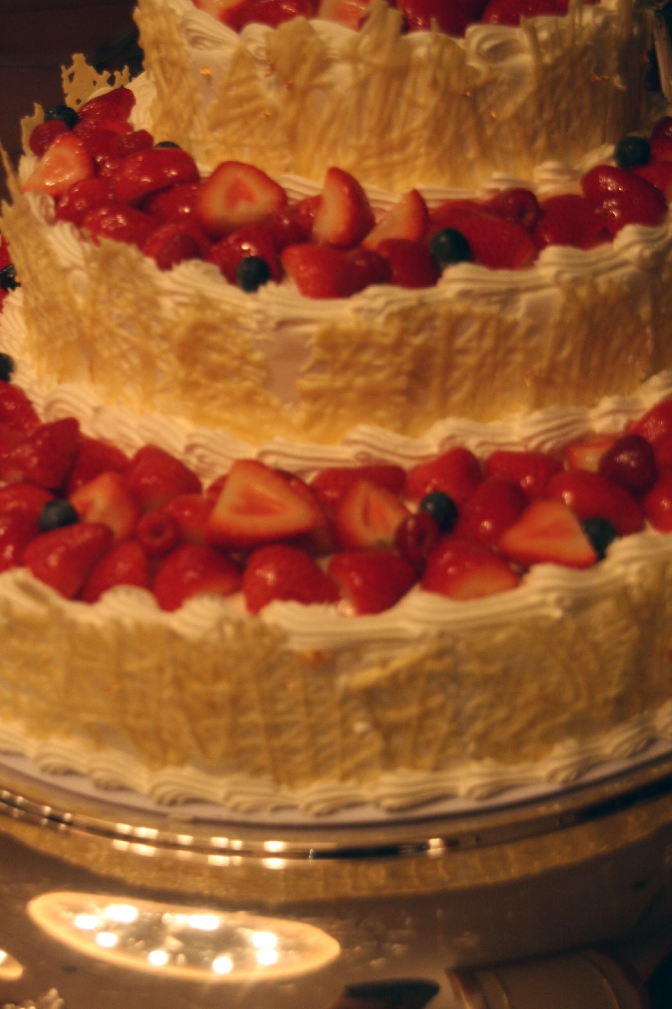 three layers cake covered in strawberries on a platter