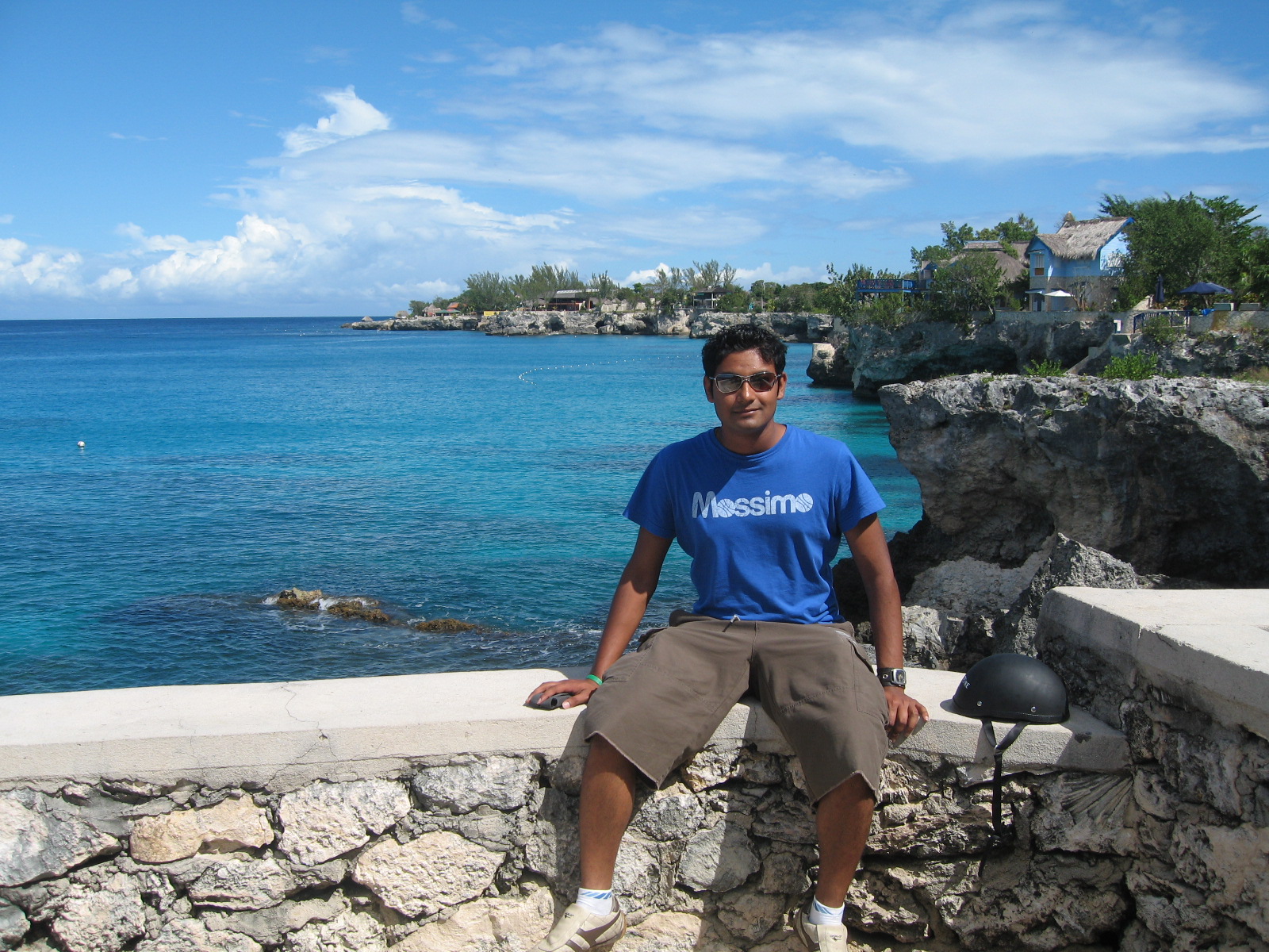 a man standing on the edge of a stone cliff overlooking the ocean