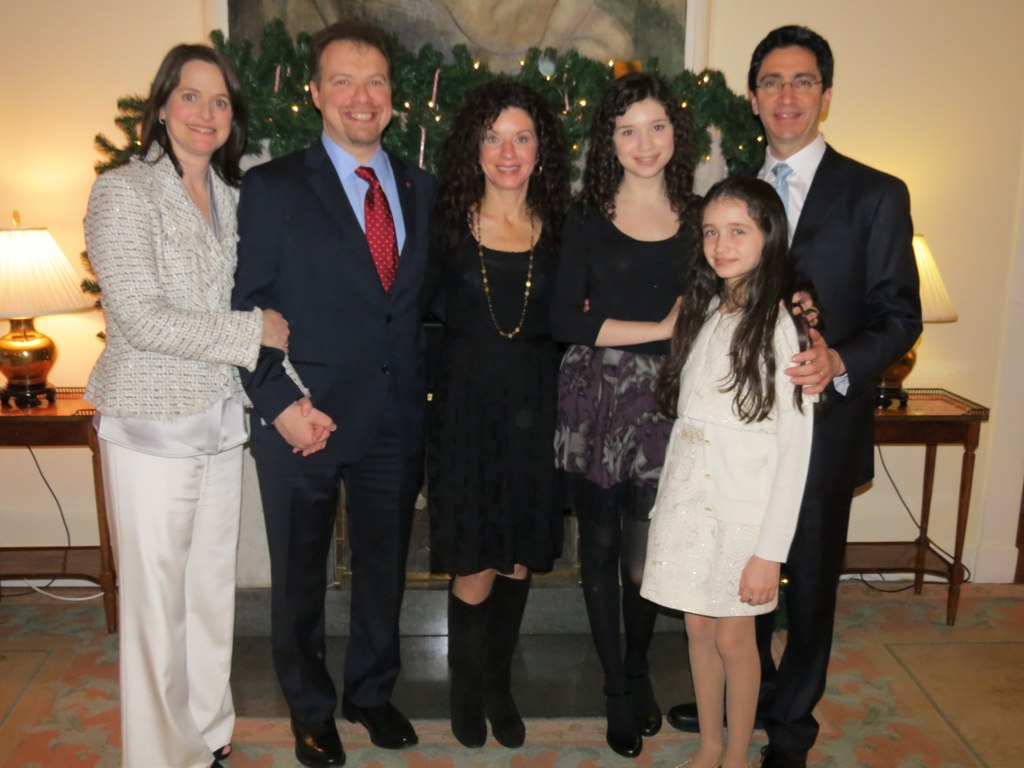 four people standing in front of a tree