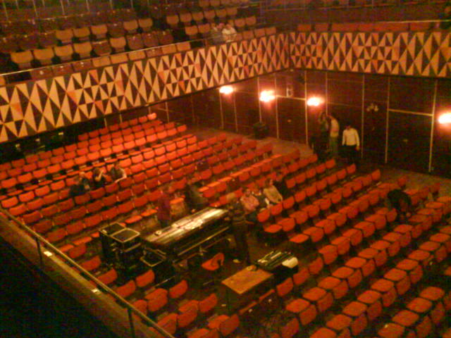 an empty theater stage with red seats