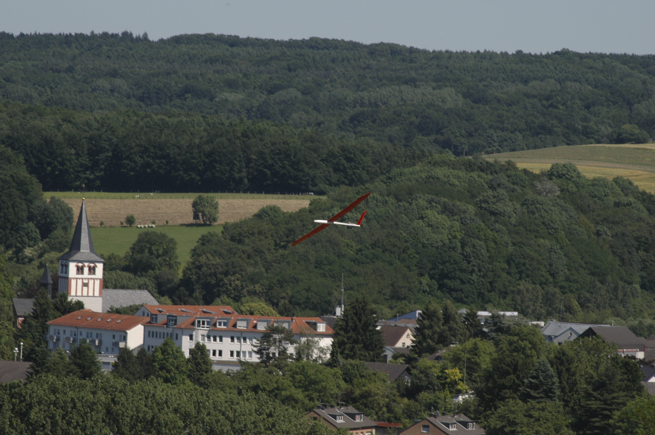 a small airplane flying low over a town