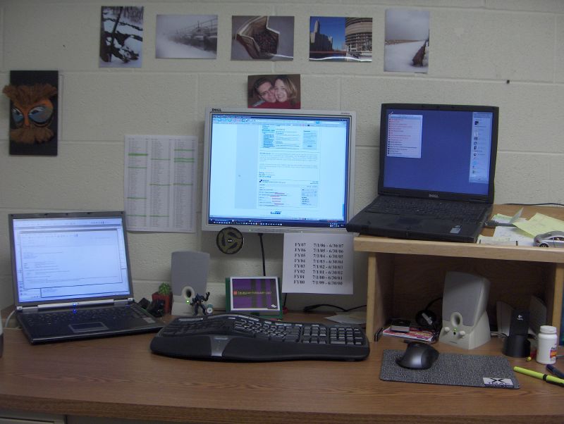 a desk with laptop, computer and desktop monitors