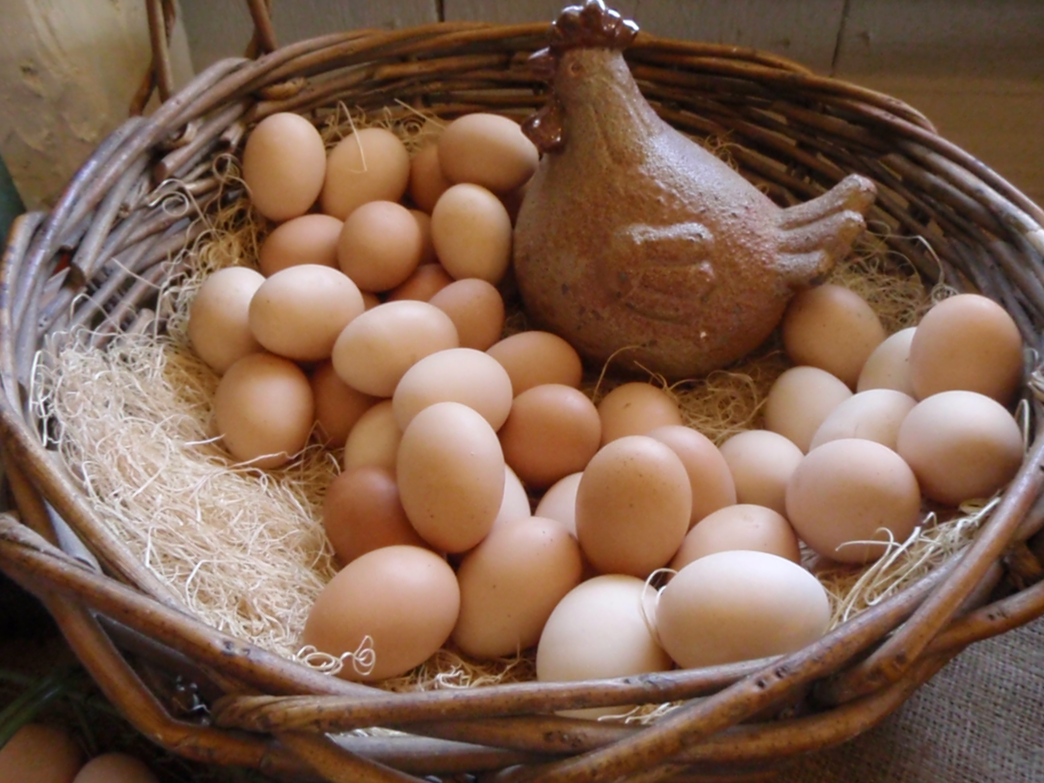 a wicker basket filled with eggs on a table