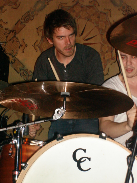 a man in a white shirt and a drummer