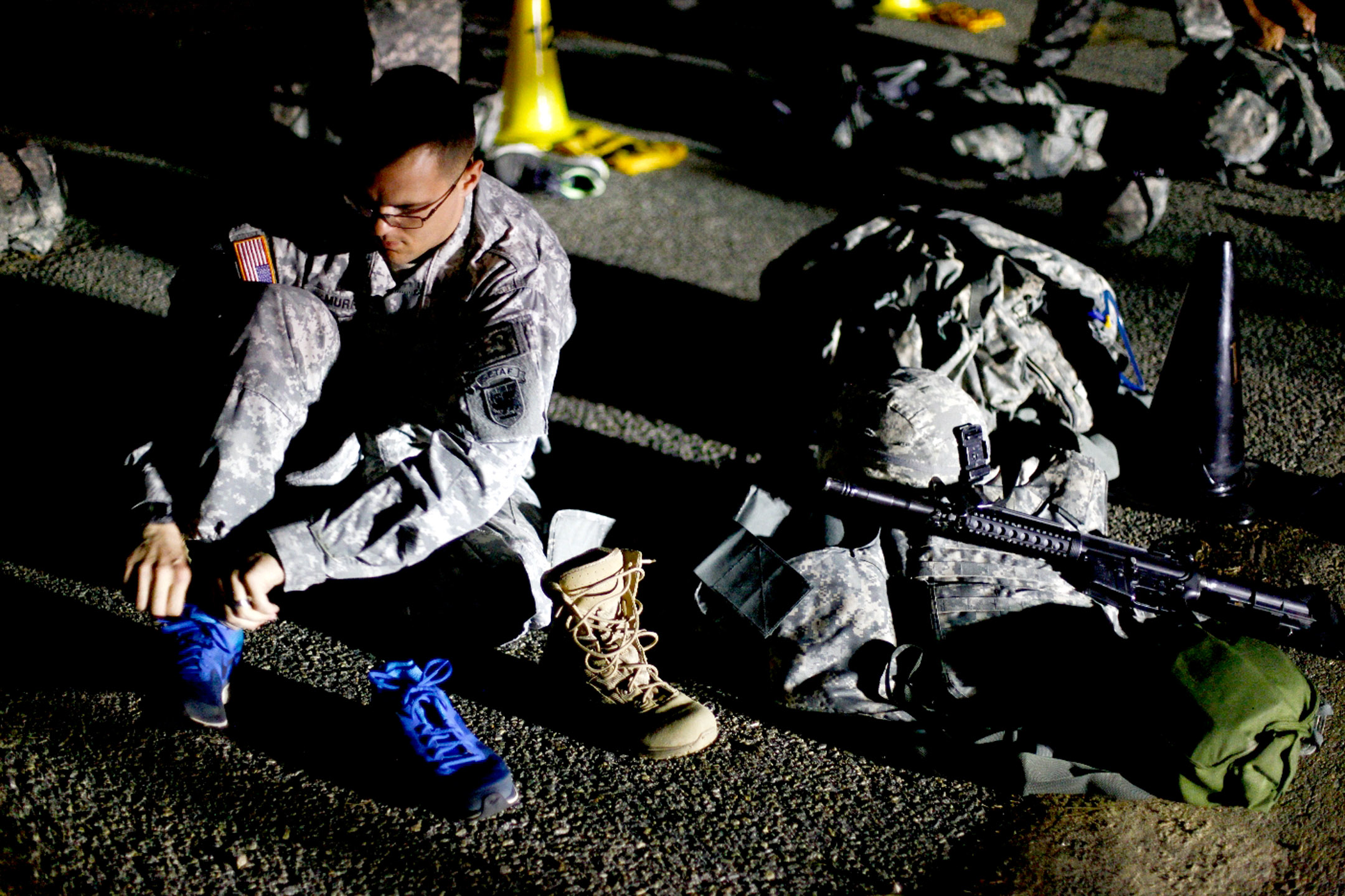 a man is sitting on the ground near a group of army personnel
