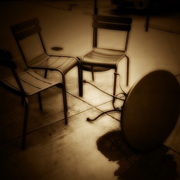 there are three chairs and one table in the dark