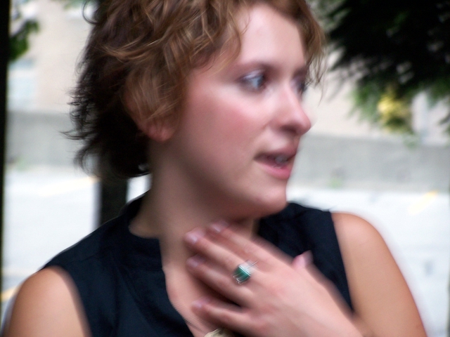 an image of a woman with short hair that is wearing a green ring