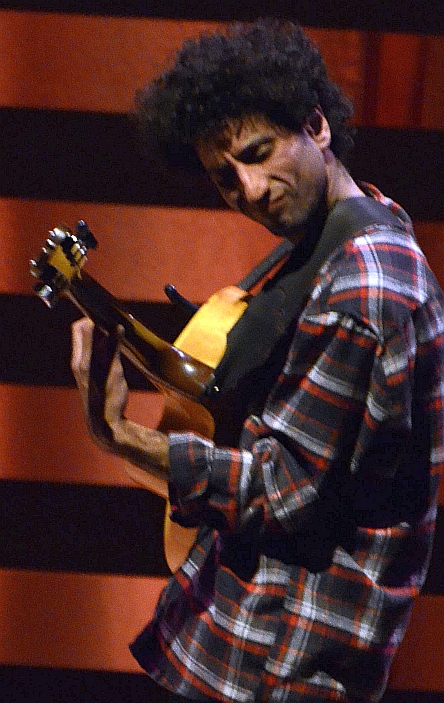 a man with an afro holding a guitar