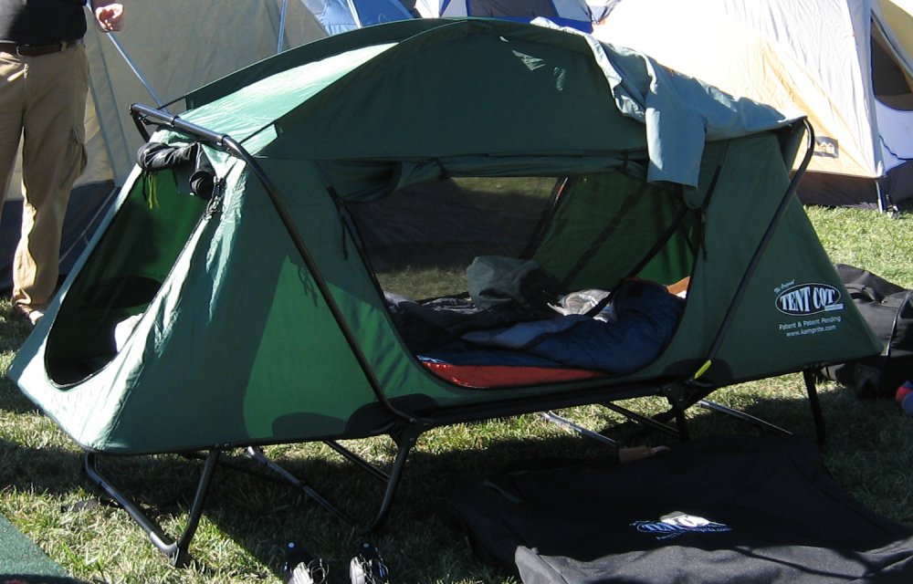 a tent set up with clothes inside is on grass