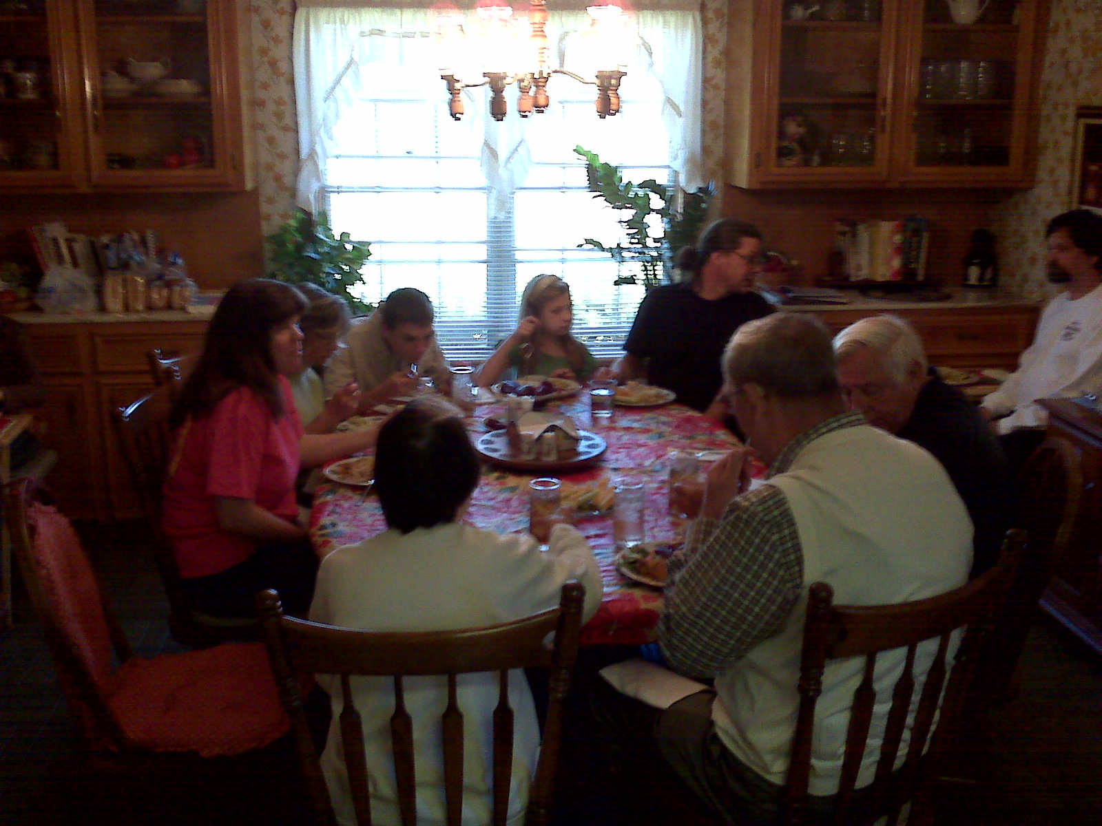 an old couple and their family are sitting around the dinner table