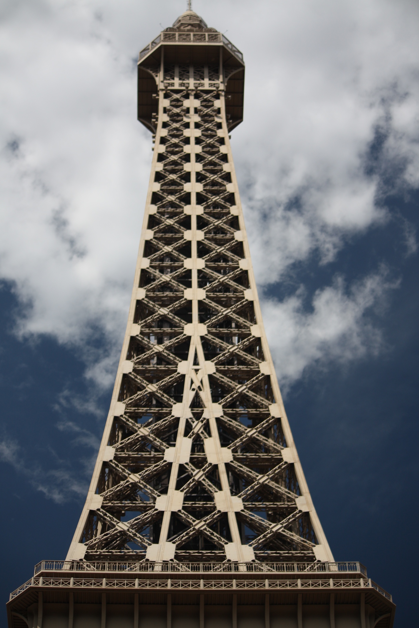 the eiffel tower from below against a cloudy sky