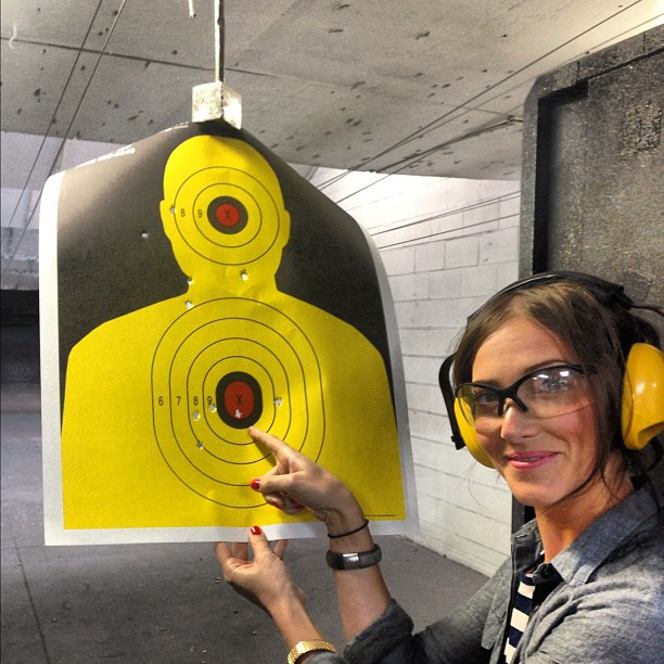 a lady with headphones is holding up a yellow target