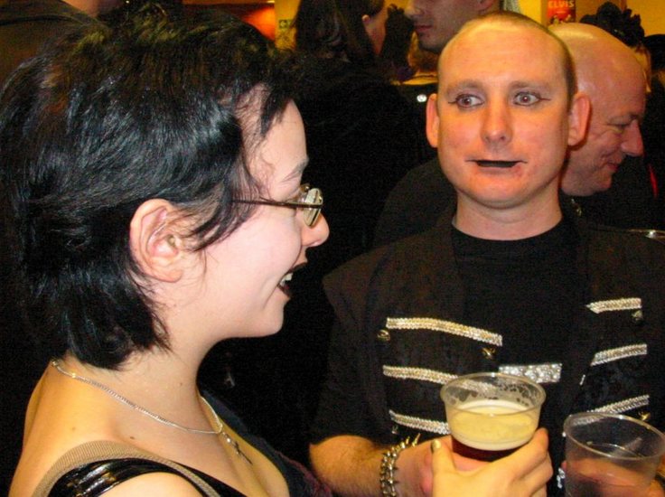 a man and woman sitting next to each other at a party