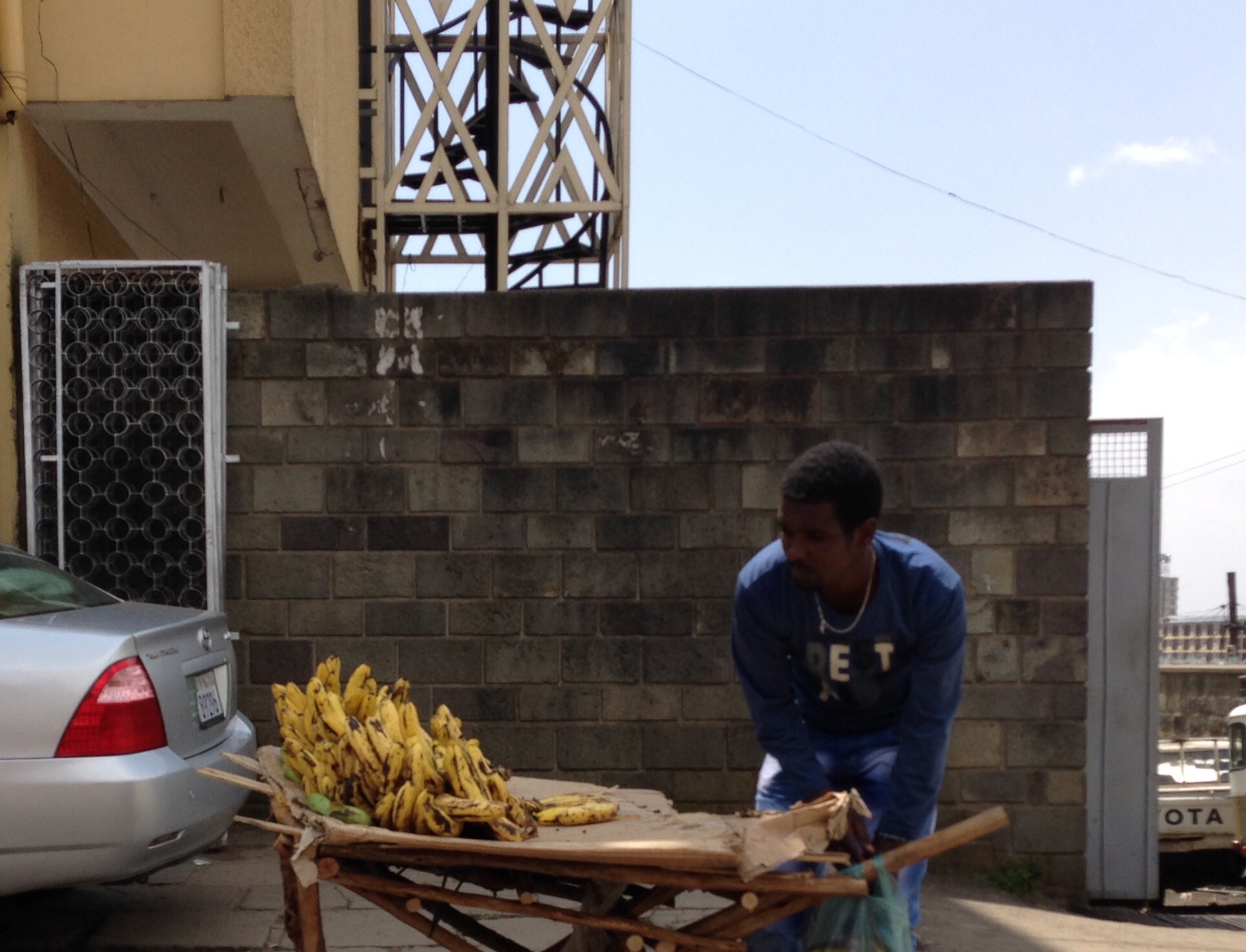 a man is hing a wheelbarrow over a cart full of bananas