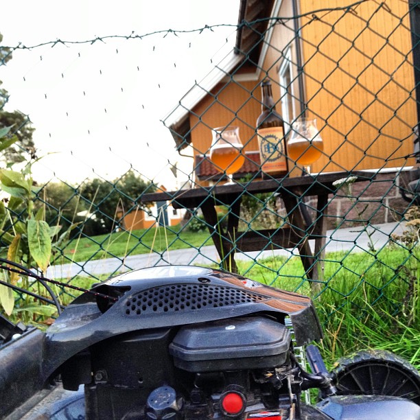 the moped is parked outside by the fence