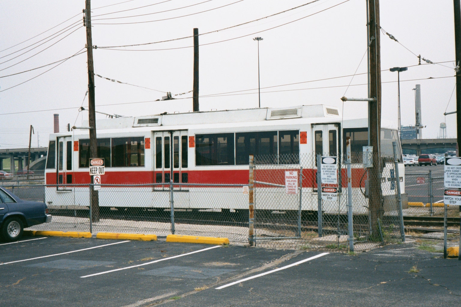 a white and red trolley car sitting in a parking lot