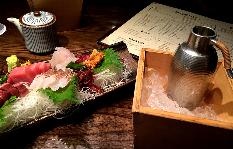 a platter full of various types of sushi on a wooden table