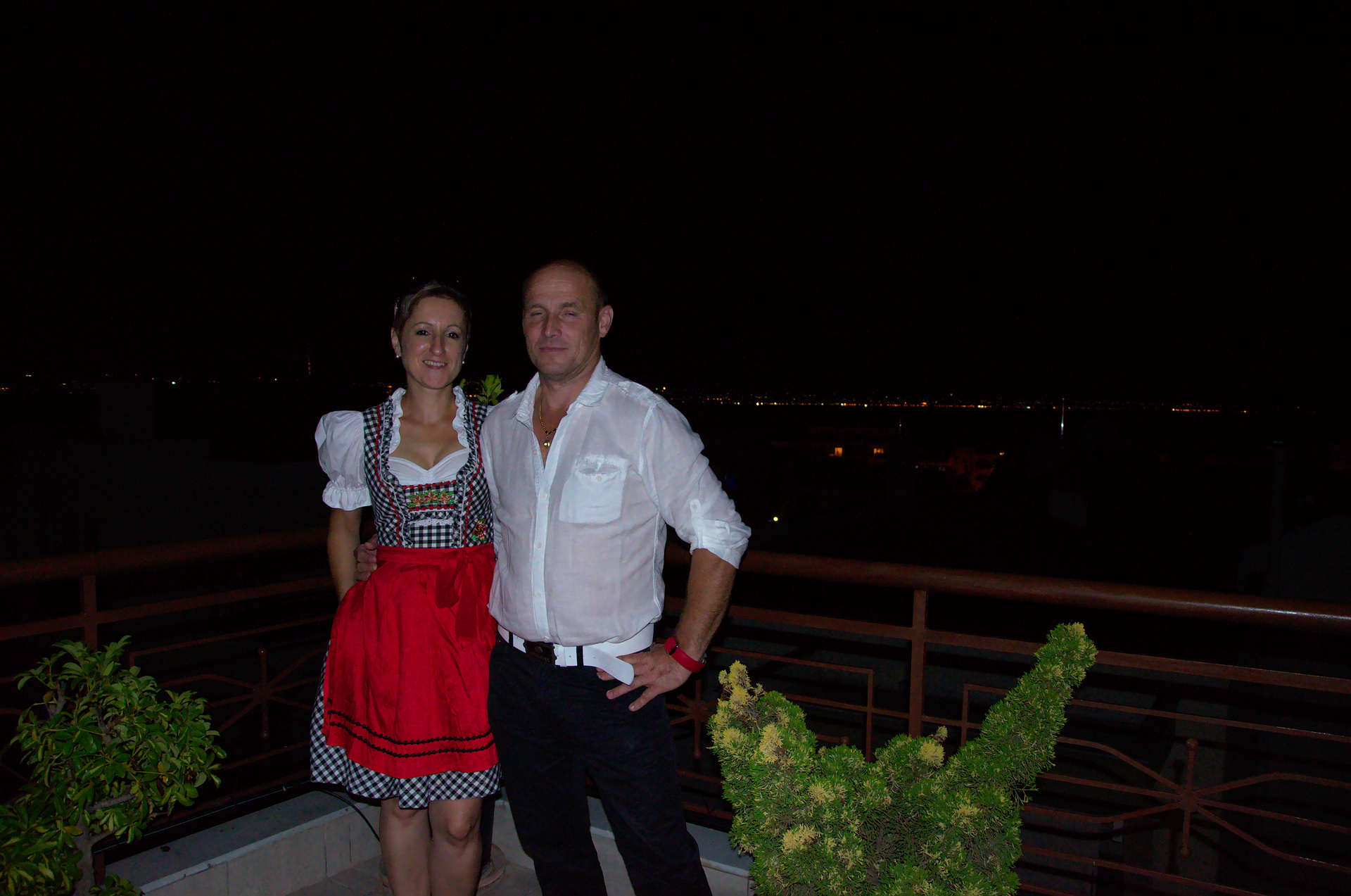 a man and woman wearing traditional bavarian clothing posing for the camera