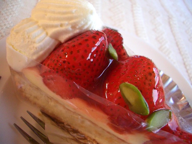 a cake covered in cream and strawberries on a plate