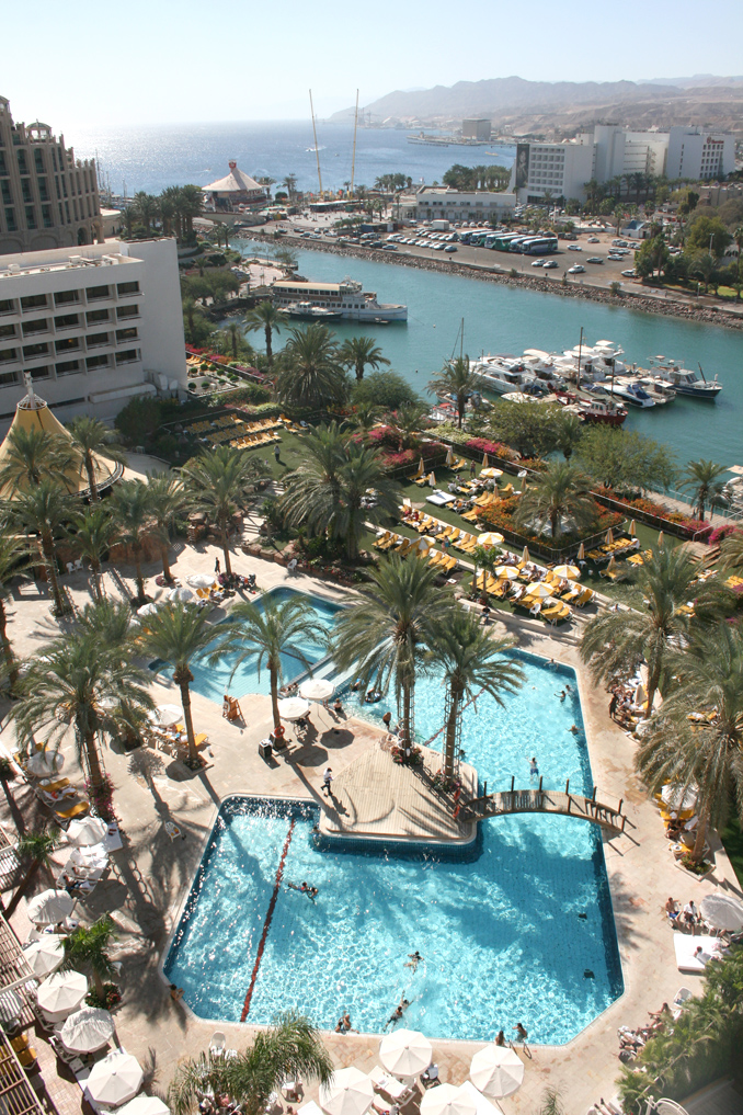 a large pool next to a harbor with sail boats