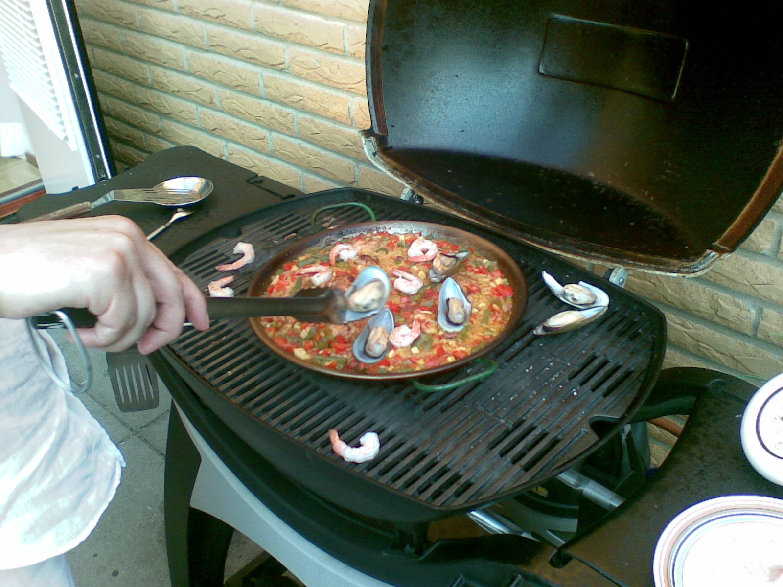 the person is preparing to put a pizza on the grill