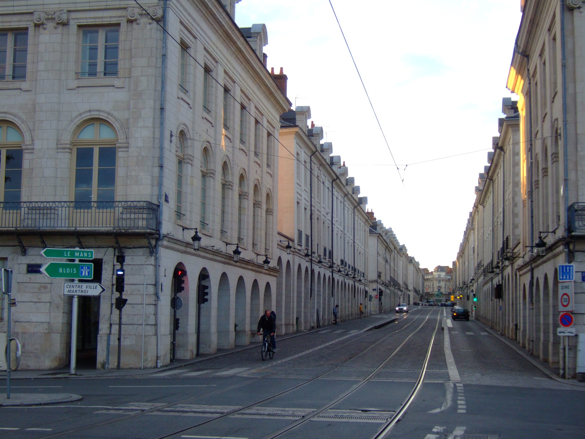 a street view with a man on a bike going down the road