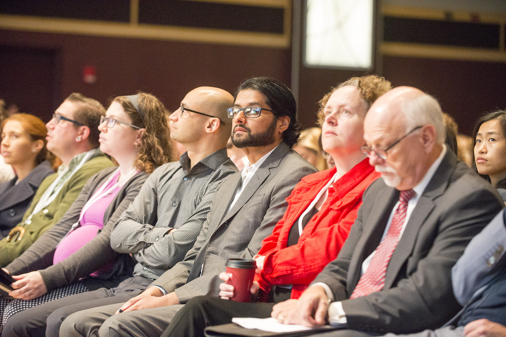 an audience at a conference with a man standing