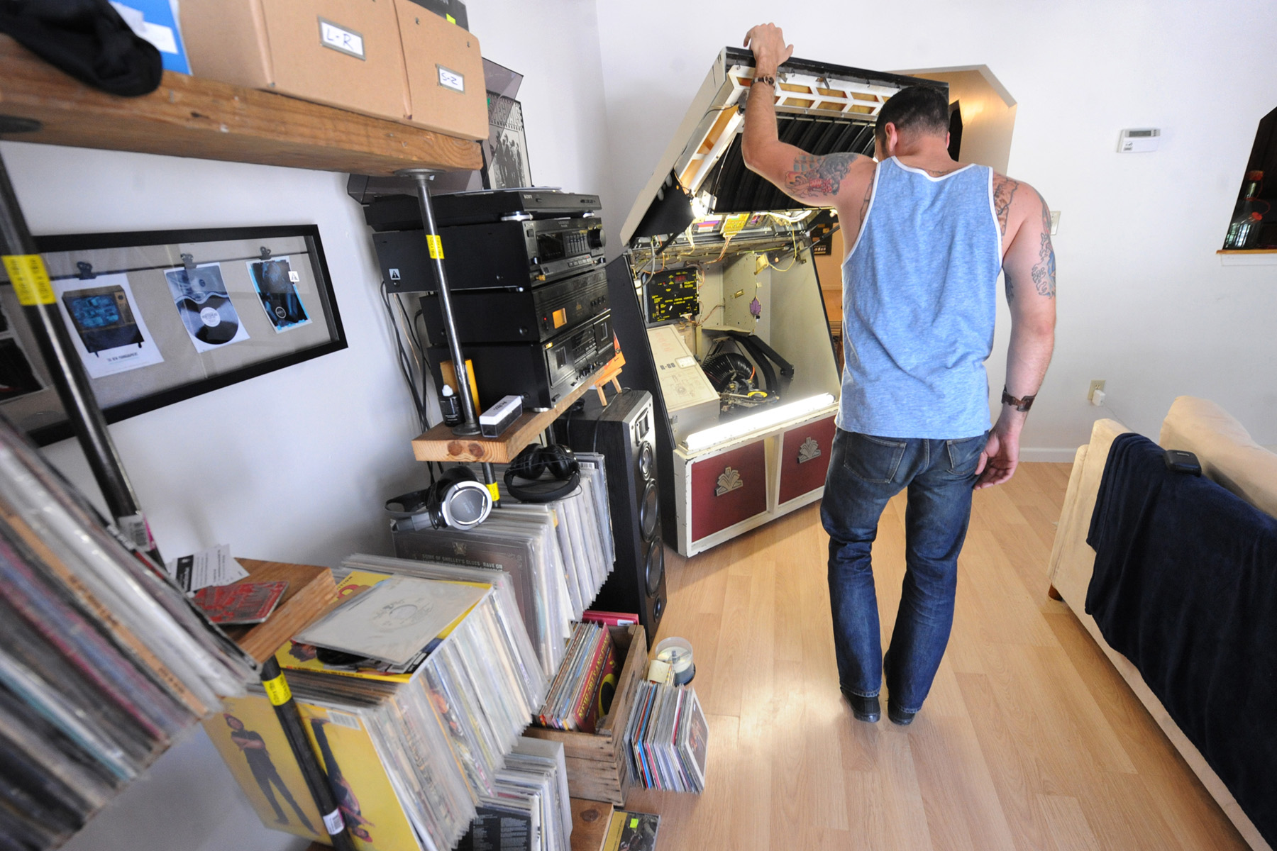 two men are walking near stacks of records in the middle of a room